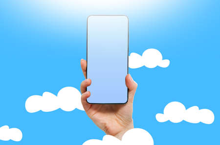 Cyberspace and online storage. A female hand holds a smartphone with a mock up. light blue background. copyspace. Cloud service and database concept.の写真素材