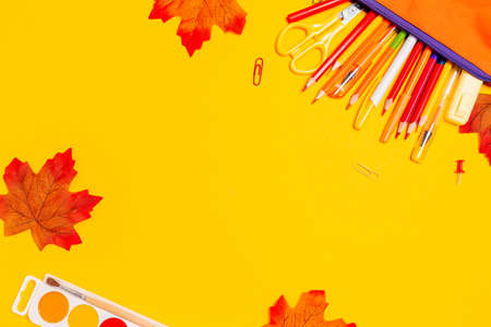 Pencil box with pens on a yellow background with maple leaves. flat lay. copyspace. Concept of back to school.の写真素材