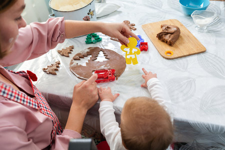 Mother and baby together cut out cookies from the dough. top view. Mother's Day concept and cooking festive home-cooked meals with children.の写真素材