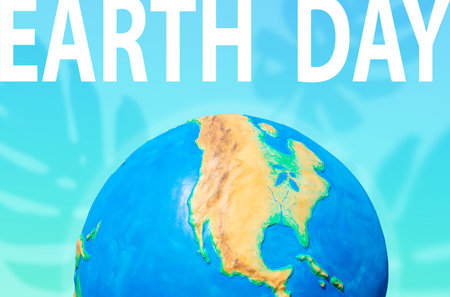 The Earth Day. Planet on a turquoise background with a silhouette of monstera leaves. Concept of Save the planet and environment.の写真素材