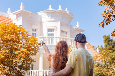 Visit to museum. Young couple of man and woman with tattoos huge on the street and look at beautiful white house. back view. The concept of relationship psychology and purchase of real estate.の写真素材