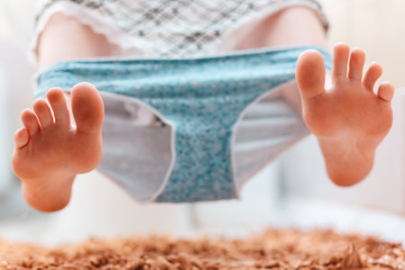 Hygiene and cystitis. A woman is sitting on the toilet with panties removed. Close up of the legs. The concept of constipation and diarrhea.の写真素材