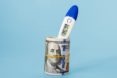 dollar exchange rate. Rolled up dollar bills with thermometer on light blue background, close-up....