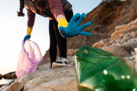 Conservation of ecology and garbage cleanup for recycling. A volunteer take a plastic bottle at the beach. bottom view. global environmental pollution.の写真素材