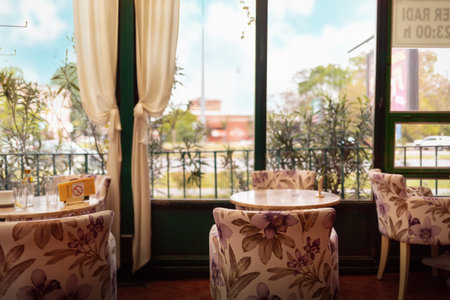 Vintage coffee shop interior with beautiful armchairs, wooden furniture and big windows. view of the park.の写真素材