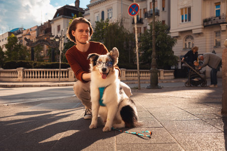 Friendship with pet. Young handsome Caucasian man posing with pure breed aussie dog poses.の写真素材