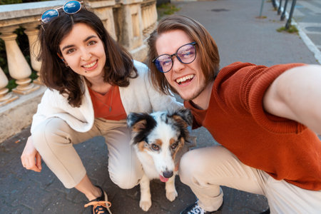 Happy young Caucasian couple with purebreed aussie dog take selfie photo. city life. training pet.の写真素材