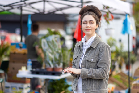 Portrait of young caucasian woman posing in background of flower spring festival. gardening.の写真素材