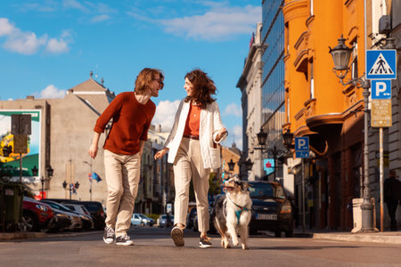 Young Caucasian couple with pet walking to the city. Training purebreed aussie dog.の写真素材