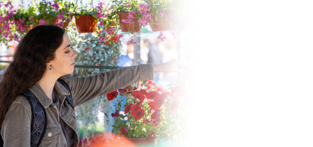 Web banner mock up. Young Caucasian smiling woman holds pot with plant. Young florist chooses plants. copyspace.の写真素材