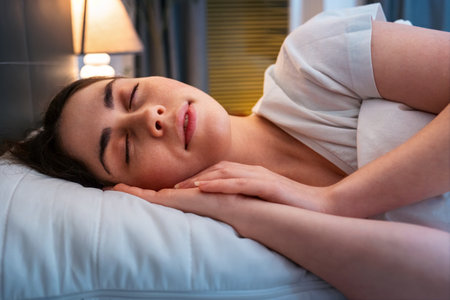 Close-up side view of young Caucasian pretty woman is fast asleep in her bed. Concept of insomnia and well sleeping with medicines.の写真素材