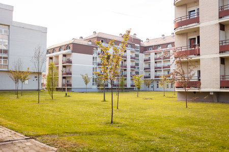 New residential area with apartment buildings and green lawn in front of house. Concept of purchase of housing and mortgageの写真素材
