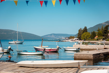 Beautiful sunny view of village pier with boats on the Mediterranean coast. Summer vacation at resort.の写真素材
