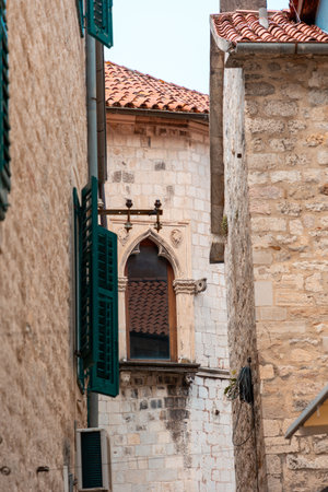 Beautiful window in Gothic building. View among buildings in old Mediterranean city. Vertical orientation.の写真素材