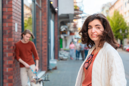 Blurred young Caucasian Man with dog and beautiful young woman passing by on street and looks at camera. Psychology of relationships.の写真素材