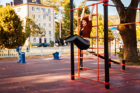 Mid adult Caucasian woman wearing sports clothes trains on Swedish wall. Exercise twisting for abs....