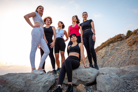 Bottom view of group of athletic women of different ages posing on beach. Concept of wellness lifestyle and sports lifestyle.の写真素材