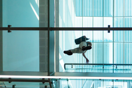 Bottom view through a transparent glass floor of a woman in a modern business center. Modern...