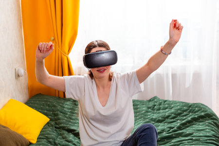 Portrait of woman engaging with a futuristic VR simulation in a modern home setting, discovering digital entertainment.の写真素材