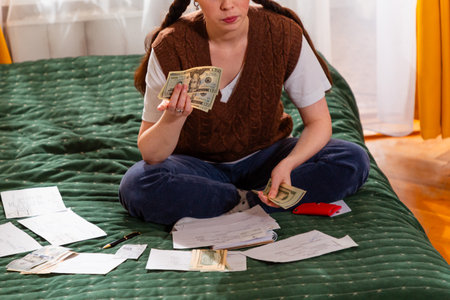 Close up of young woman reviewing bills planning savings and managing economic strategies for financial security. concept of financial intelligence and economy.の写真素材