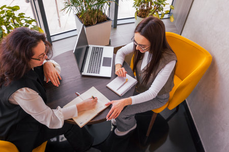 Women coordinating launch assets while sipping espresso in a relaxed setting, concept of flexibility...