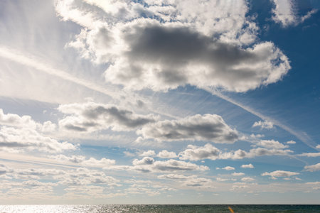 Blue sky with clouds, sunlight and ocean. Horizon. Azure heaven. Cloudscape with copy space. Concept of freedom.の写真素材