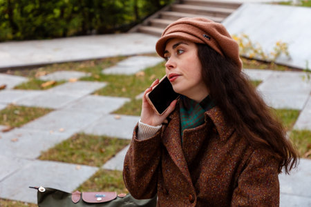 Relaxed city walk with a young Caucasian woman who is dressed in autumn fashion and engaged in an...
