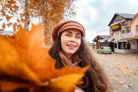 Fall elegance captured in motion as a young woman strolls through quiet city corners, enjoying the...