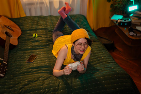 Caucasian teen girl with game controller smiling and relaxing. Cozy bed and warm room design....