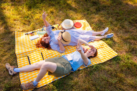 Caucasian mother and daughter spending summer day together in the park on a blanket. Concept of...