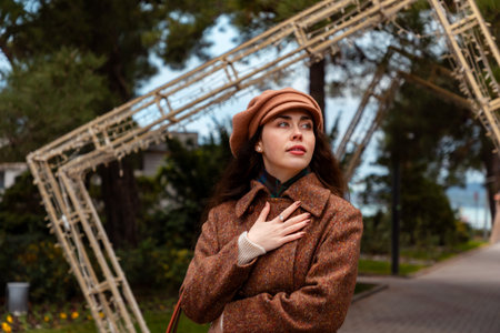 Portrait of stylish woman walks through the urban landscape in autumn, showing signs of calm and emotional distanceの写真素材