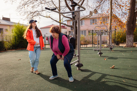 Senior Caucasian woman performs rehabilitation exercises with a professional trainer in a public...
