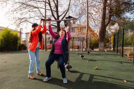 Senior woman following rehabilitation program with outdoor exercise after an operation. Sport...