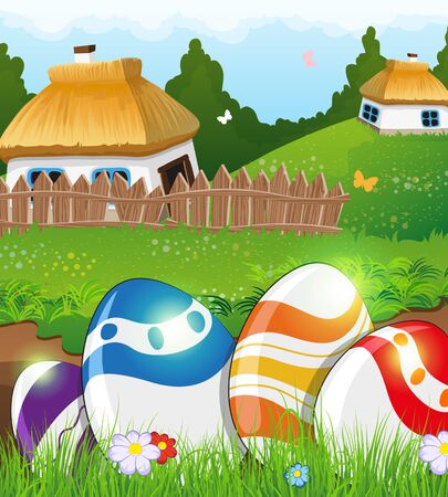 Painted Easter eggs in the grass on a green meadow. Two small rural houses with thatched roofs in the backgroundのイラスト素材