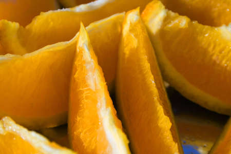 Juicy orange segments on a plate with reflection of the skyの写真素材