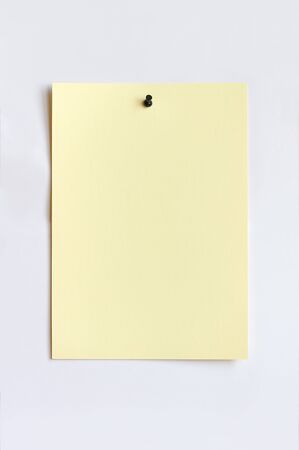 Light yellow sheet attached with pushpin  Isolated on white の写真素材
