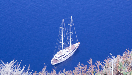 yacht anchored to shore in Greece, Santorini Island - blue waterの写真素材