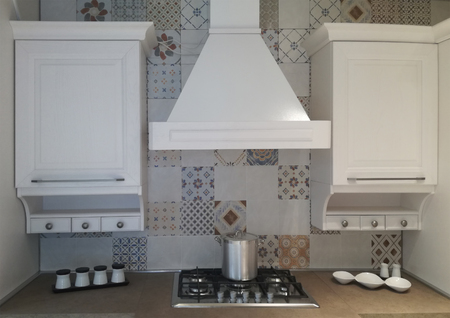 Detail cooking space in the kitchen - with stove, hood and white cabinetsの写真素材