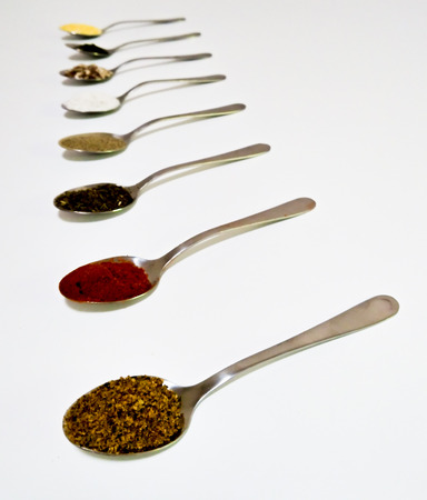Spicy spoonfuls - pepper, salt, seeds, paprika, thyme, coriander - for a tasty and healthy mealの写真素材