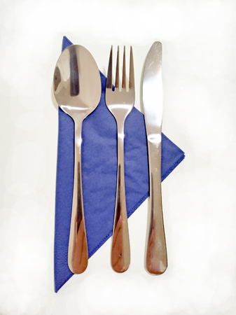 Blue bowl with tableware - spoon, fork and knife - table / dinner / breakfast / lunch arrangementの写真素材