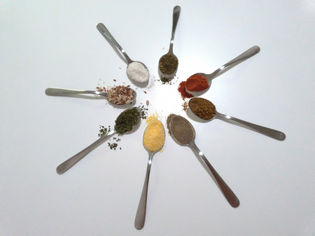 Spicy spoonfuls - pepper, salt, seeds, paprika, thyme, coriander - for a tasty and healthy meal - sun / circle of spoonの写真素材