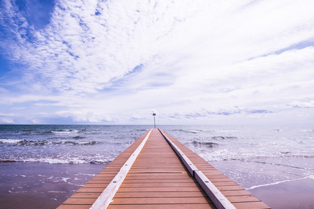 Beach landscape with pier and waves of the sea in the sand (Jesolo, Italy)