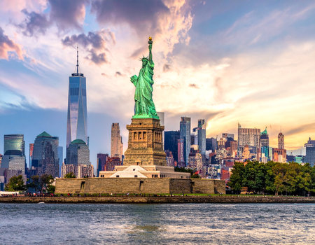 New York City Manhattan skyline panorama with Statue of Liberty over Hudson River at sunset.の写真素材