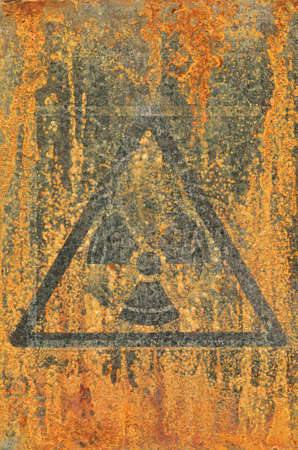 Ionizing radiation.Hazard symbol.Mark from an old sticker on a rusty metal surface.の写真素材