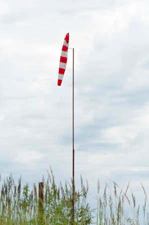 Wind cone.Wind strength indicator in the form of a striped cone near the yacht-club.の写真素材