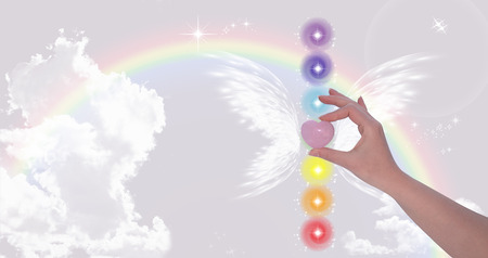 Hand holding Rose Quartz heart and The Seven Chakrasの写真素材