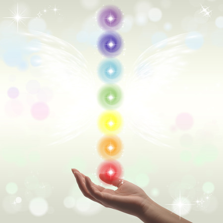 Healing Hands and seven chakras on a sparklingpastel coloured backgroundの写真素材