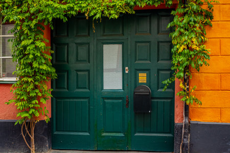 Green door on verdant, colorful house at Gamla Vaster area in Malmo, Sweden