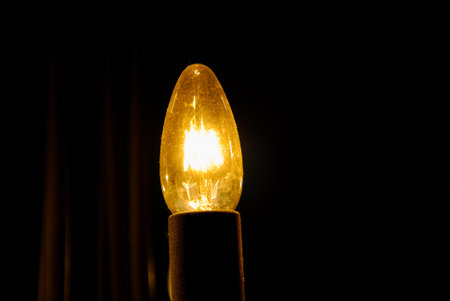Yellow light bulb against dark background