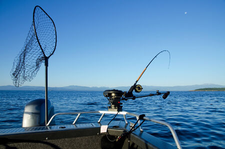 Fishing rod on bow of boat with landing net の写真素材